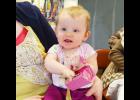 Ten month old Evelyn Mulvaney was happy to take home this little pink purse from Saturday’s auction. Photo by St. Charles Press Editor Laura Berndt. 