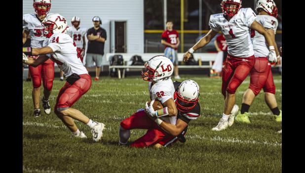 Marek Leif, no. 22 Cardinal, is tackled by Eli Hester, no. 6 Falcon.